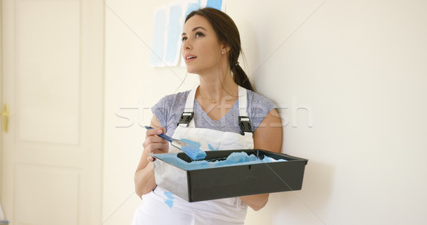 Stock photo: Thoughtful young woman contemplating her handiwork