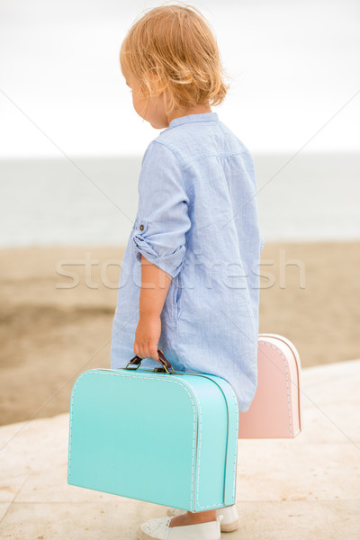 Little girl carrying her suitcases at the seaside Stock photo © dash