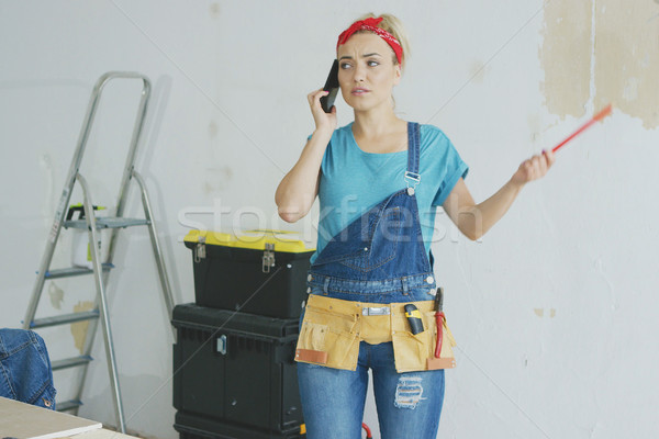 Doing home repairs woman talking on smartphone  Stock photo © dash