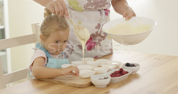 Parent pouring muffin batter into holders Stock photo © dash