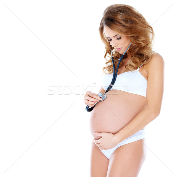 Pregnant young woman listening to her baby Stock photo © dash