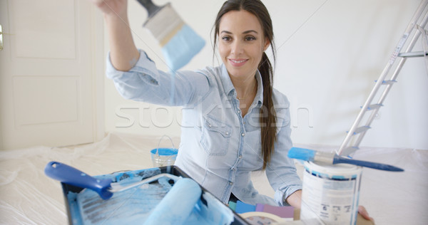 Smiling young woman checking out a blue paint Stock photo © dash