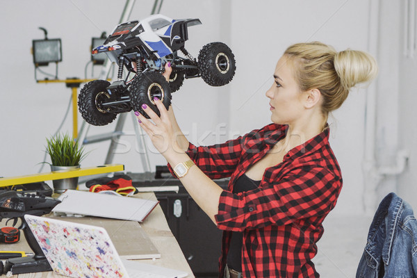Woman examining radio-controlled car in workshop Stock photo © dash