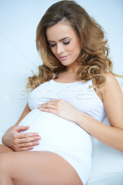 Foto d'archivio: Giovani · donna · incinta · toccare · pancia · seduta · divano