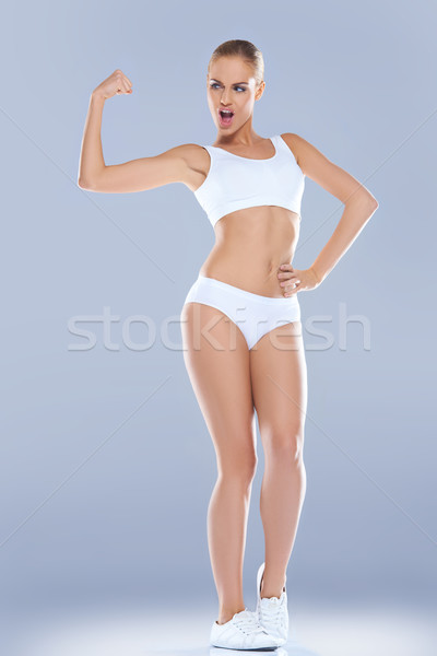 Fun image of a woman displaying her biceps Stock photo © dash