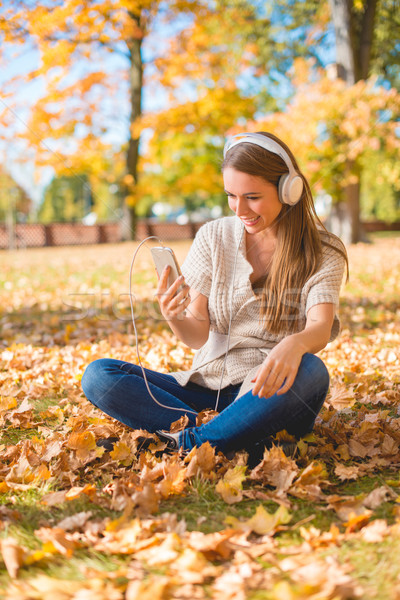 Young woman listening to music in an autumn park Stock photo © dash