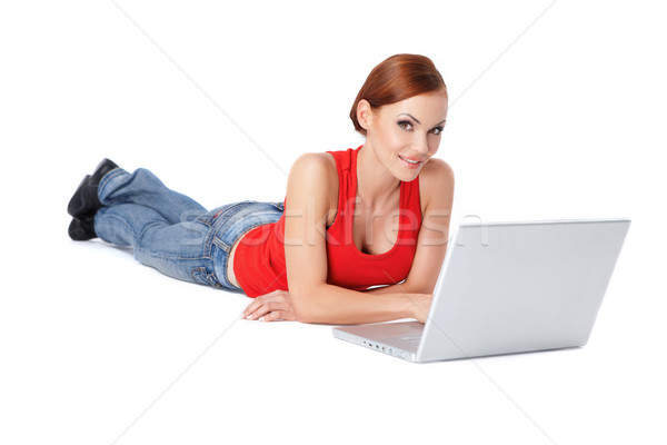 Cute female lying down and using a laptop Stock photo © dash