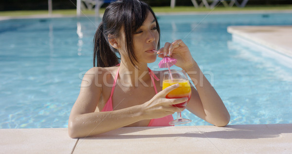 Pretty young woman sipping a cocktail in  pool Stock photo © dash