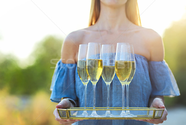 Happy woman holding tray with champagne sparkling wine into glas Stock photo © dashapetrenko