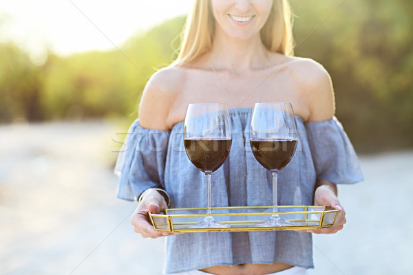 Happy woman holding tray with red wine into glasses outdoors at  Stock photo © dashapetrenko