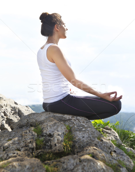 Attractive young woman doing a yoga pose for balance on top of h Stock photo © dashapetrenko