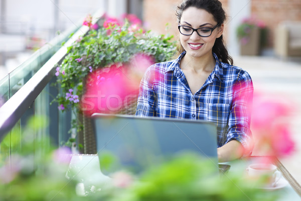 Beautiful young freelancer woman using laptop computer sitting a Stock photo © dashapetrenko