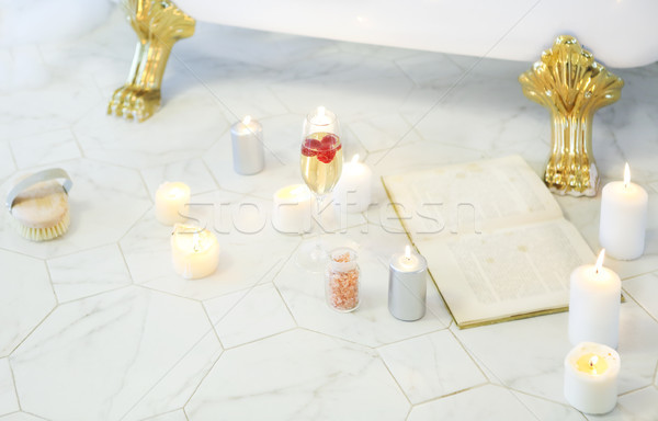 Close up of candles, book, glass of champagne by the bath Stock photo © dashapetrenko