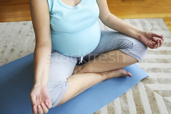 Terhes nő meditál ül lótusz pozició közelkép Stock fotó © dashapetrenko