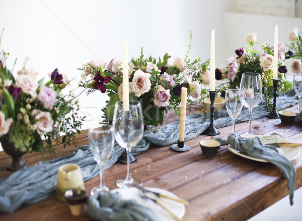 Bouquets of pink flowers on a table set for dinner with candles Stock photo © dashapetrenko