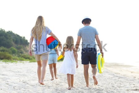 Young family having fun running on beach at sunset. Stock photo © dashapetrenko