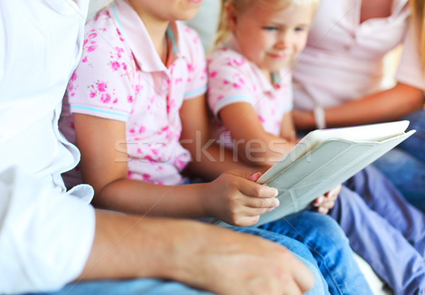Happy family of mother, father and daughters using a tablet comp Stock photo © dashapetrenko