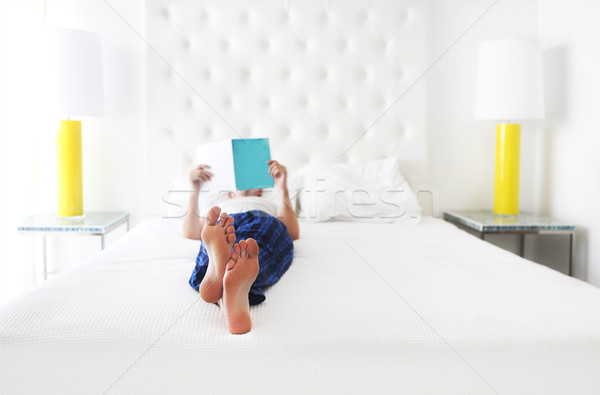 Young man reading book in the bed Stock photo © dashapetrenko