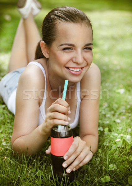 Beautiful young girl lying on the grass  Stock photo © dashapetrenko