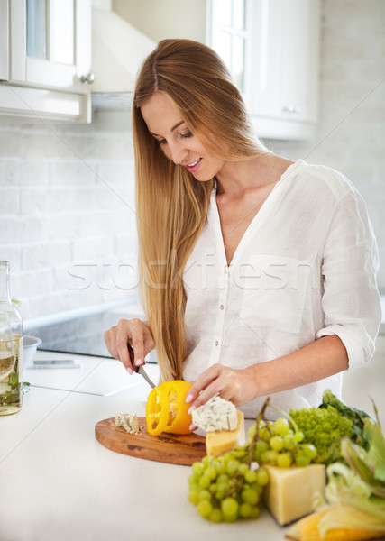 Сток-фото: молодые · улыбающаяся · женщина · приготовления · овощей · кухне · женщину