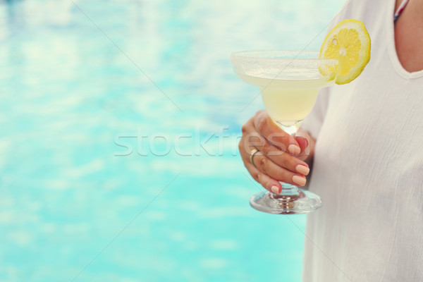 Cocktail glass in womans hand near the pool Stock photo © dashapetrenko