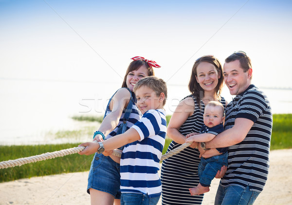 Tug of war - family playing on the beach Stock photo © dashapetrenko