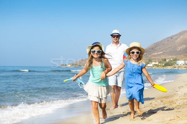 Happy young family having fun running on beach at sunset. Family Stock photo © dashapetrenko