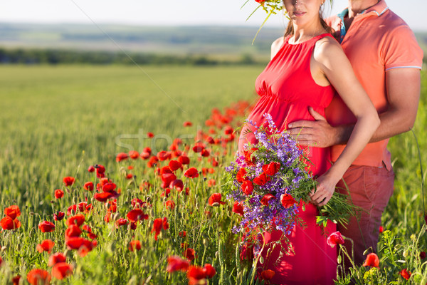 Young beautiful pregnant couple in poppy field Stock photo © dashapetrenko
