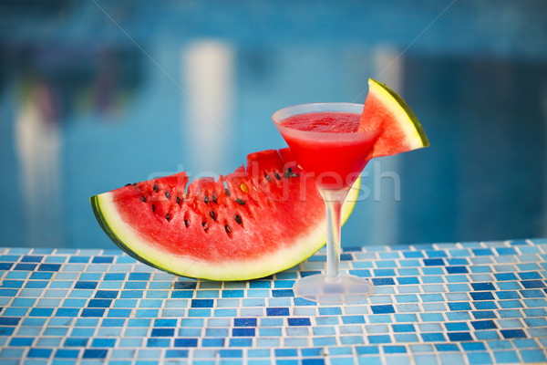 Glass of watermelon cocktail with watermelon slice near pool Stock photo © dashapetrenko