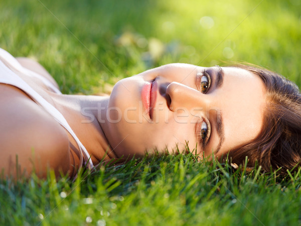 Beautiful young girl relaxing on green grass Stock photo © dashapetrenko