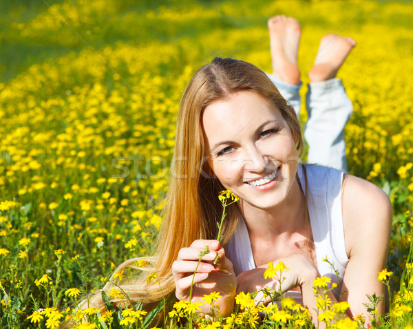 Stock photo: Young beautiful blond girl laying on the daisy flowers field. Ou
