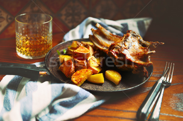 Braised goat meat with sauce and roasted potatoes in the pan Stock photo © dashapetrenko