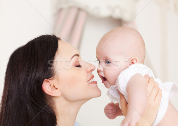 Stock photo: Happy smiling mother with six month old baby girl 