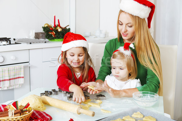 Two little girls and mother baking Christmas cookies in the kitc Stock photo © dashapetrenko