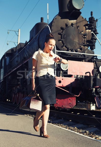 Woman with a suitcase looks at her clock  Stock photo © dashapetrenko