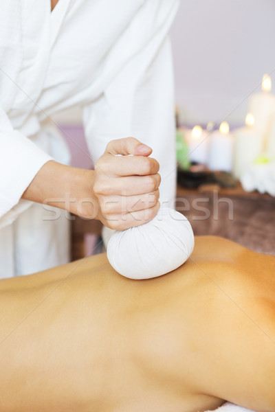 Beautiful young woman having back massage with pouch of rice Stock photo © dashapetrenko