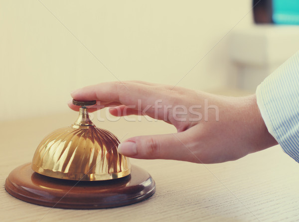 Stock photo: Hand of a woman using a hotel bell