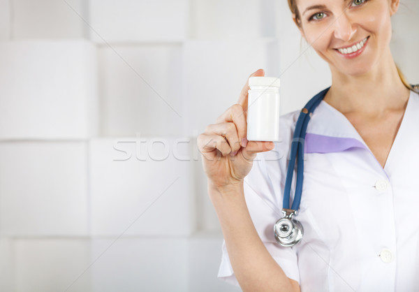 Foto stock: Bastante · mujer · sonriente · médico · uniforme · senalando · medicina