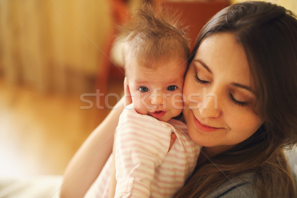 Stock photo: Young mother holding her newborn child. Mom nursing baby