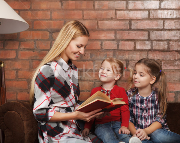 Happy mother and her little daughters indoors. Brick background Stock photo © dashapetrenko