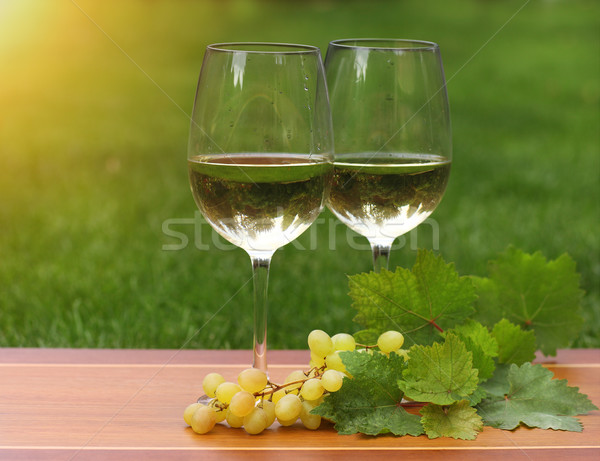 Foto stock: Dois · óculos · vinho · branco · uvas · folhas · verdes · madeira