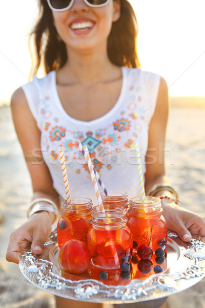 Happy young woman holding a dish with a drinks at summer party Stock photo © dashapetrenko