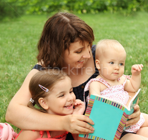 Mother and children reading a book i Stock photo © dashapetrenko