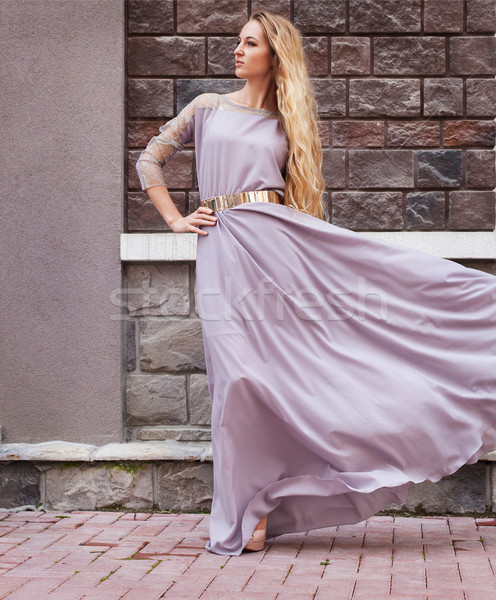 Stock photo: Beautiful blond woman in long dress walking 