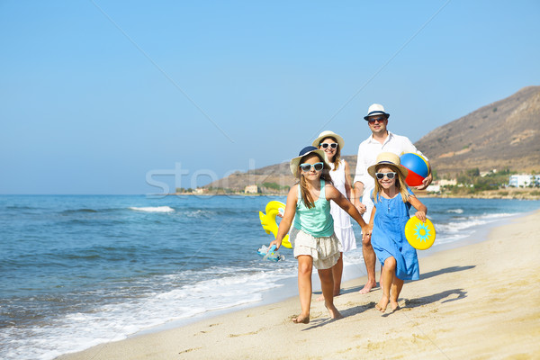 Happy young family having fun running on beach at sunset. Family Stock photo © dashapetrenko