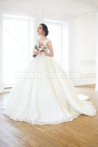 Piękna brunetka kobieta bukiet stwarzające suknia ślubna Zdjęcia stock © dashapetrenko