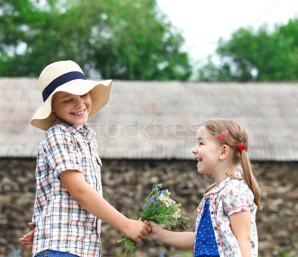Little boy gives flowers to the little girl Stock photo © dashapetrenko