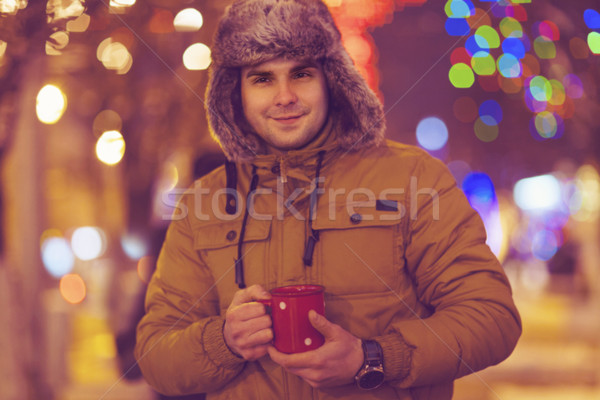 Portrait of young man drinking tea outdoor in wintertime Stock photo © dashapetrenko
