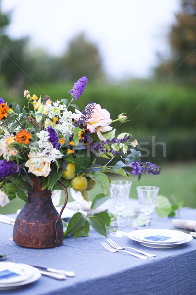 Bouquet of pink, violet and yellow flowers on a table set for di Stock photo © dashapetrenko