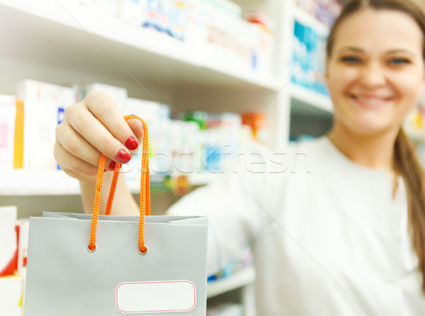 Closeup of a female pharmacist holding packet in her hand at dru Stock photo © dashapetrenko
